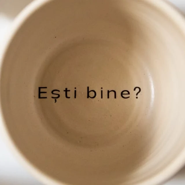 Interiorul unei căni EMSENSA văzut de sus, cu mesajul „Ești bine?” pe fundul cănii